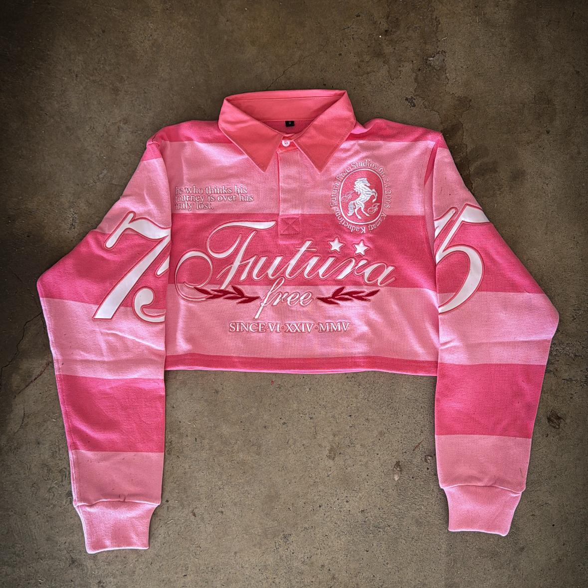 Pink long-sleeve polo shirt with branding on a concrete floor